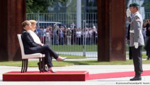 Merkel und das Zittern: Hymne im Sitzen